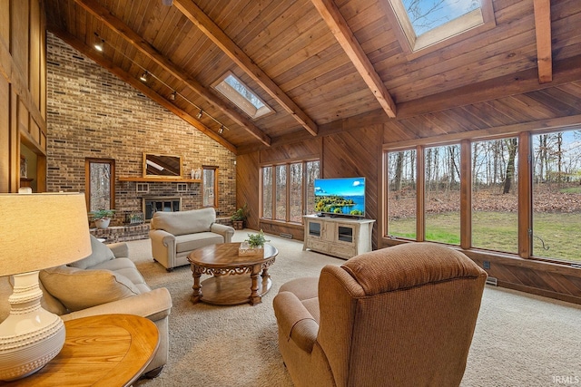 living room featuring beam ceiling, a skylight, wood walls, and high vaulted ceiling