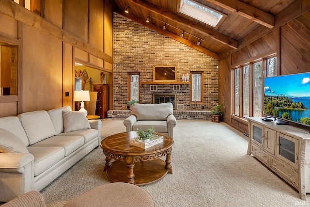 living room with a skylight, a brick fireplace, wooden walls, high vaulted ceiling, and beamed ceiling