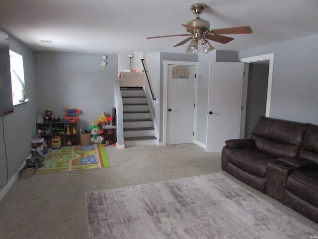 living room featuring carpet flooring, ceiling fan, and a textured ceiling