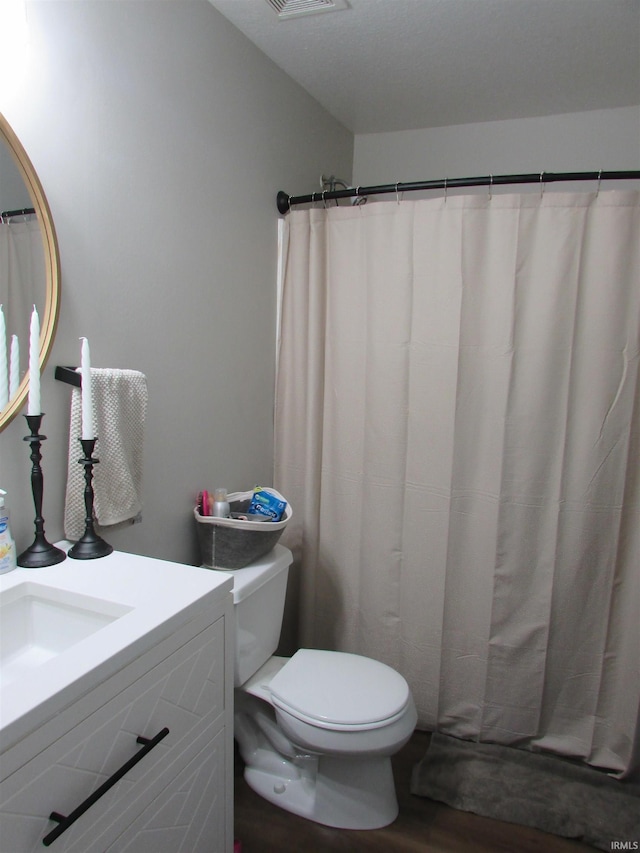 bathroom with vanity, hardwood / wood-style flooring, and toilet