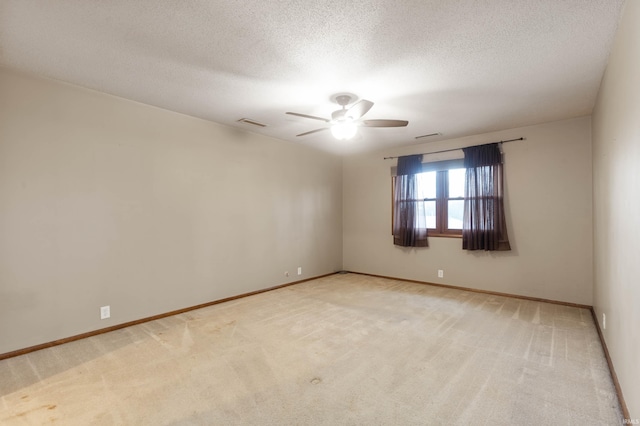 carpeted spare room with ceiling fan and a textured ceiling