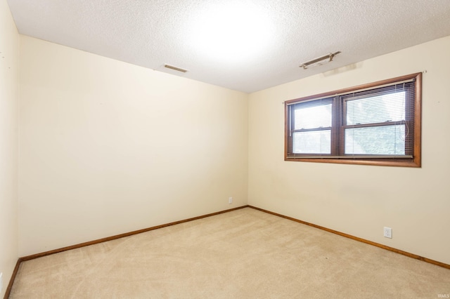 carpeted empty room featuring a textured ceiling