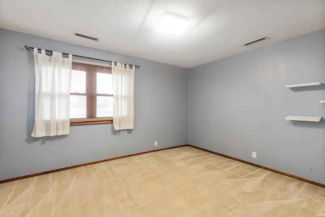 unfurnished room with a textured ceiling and light carpet