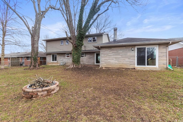 back of property featuring a yard and a fire pit