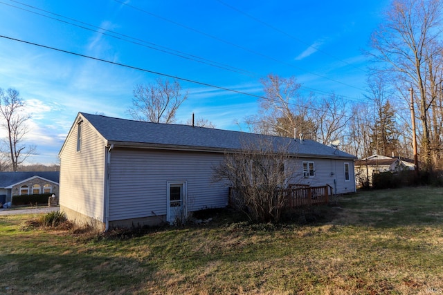 rear view of property featuring a lawn and a wooden deck