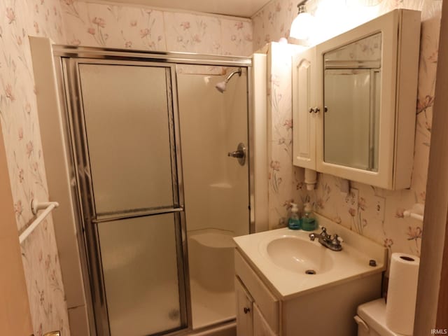 bathroom with toilet, vanity, and walk in shower