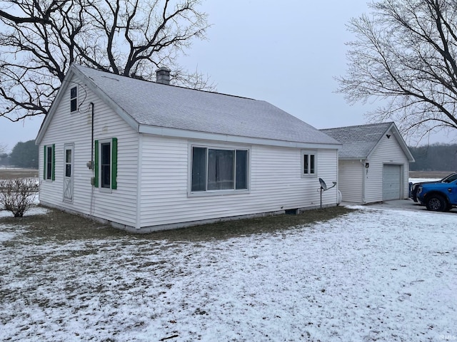 view of front of property with a garage and an outdoor structure