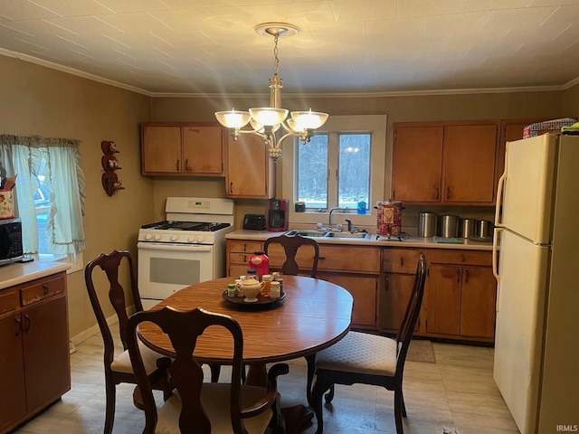 kitchen with crown molding, sink, decorative light fixtures, and white appliances