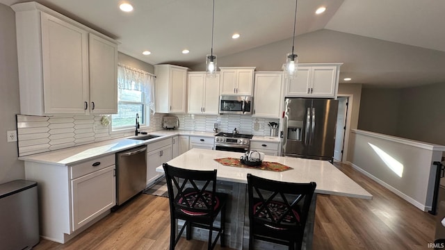 kitchen with a kitchen island, sink, white cabinetry, and stainless steel appliances