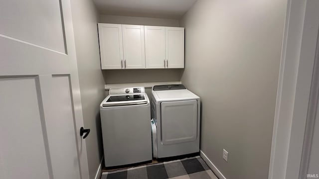 clothes washing area with cabinets and washer and dryer