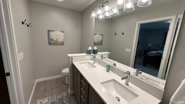 bathroom with vanity, toilet, and wood-type flooring