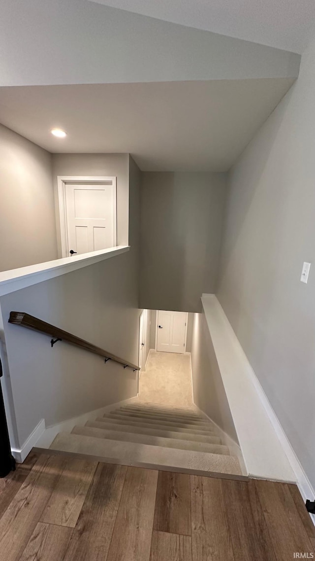 stairs featuring hardwood / wood-style floors