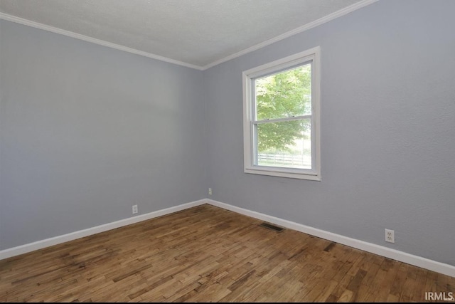 spare room featuring hardwood / wood-style flooring and crown molding