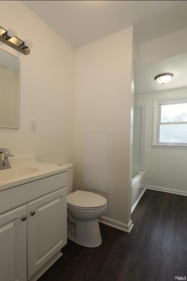 bathroom with hardwood / wood-style floors, vanity, and toilet