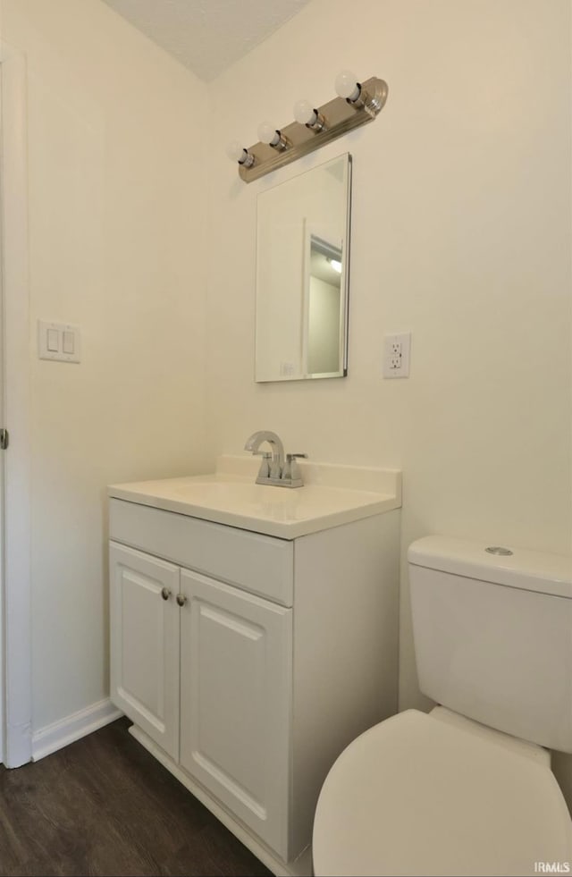 bathroom with hardwood / wood-style floors, vanity, and toilet