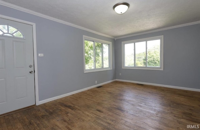 foyer entrance featuring a textured ceiling, dark hardwood / wood-style floors, and ornamental molding