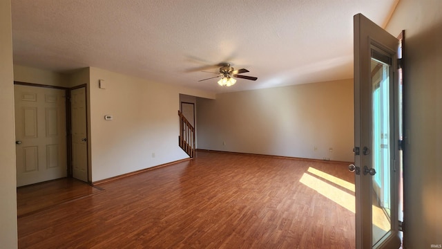 empty room with hardwood / wood-style flooring, ceiling fan, and a textured ceiling