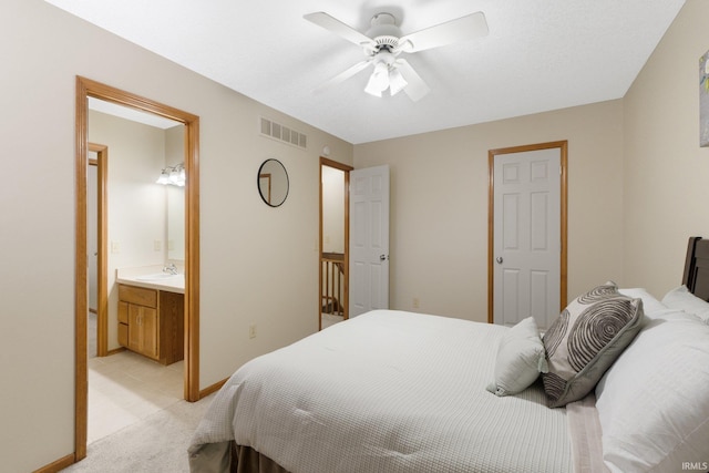 carpeted bedroom with ensuite bathroom, ceiling fan, and sink