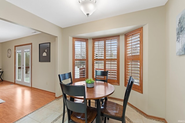 dining space featuring french doors and light tile patterned flooring