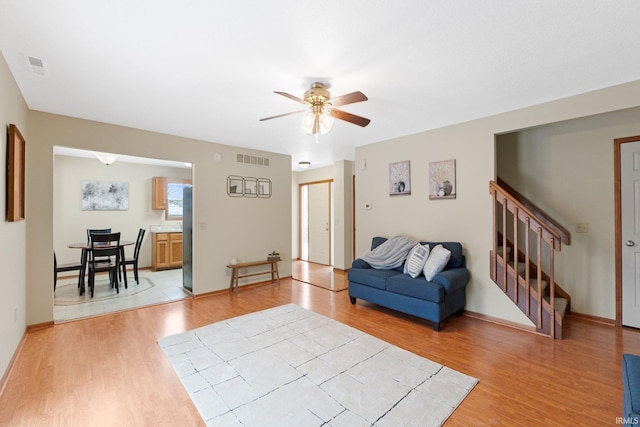 living room featuring ceiling fan and light wood-type flooring