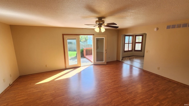 unfurnished room featuring ceiling fan, wood-type flooring, and a wealth of natural light