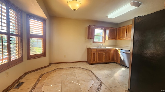 kitchen with sink, light tile patterned floors, and stainless steel appliances