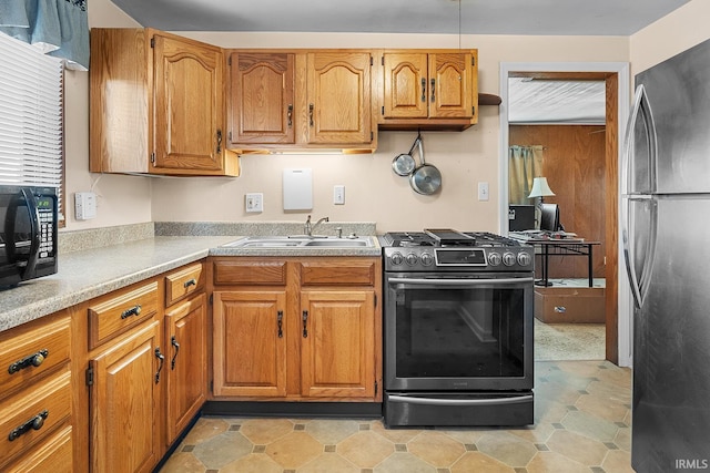 kitchen with sink, fridge, and stainless steel range oven