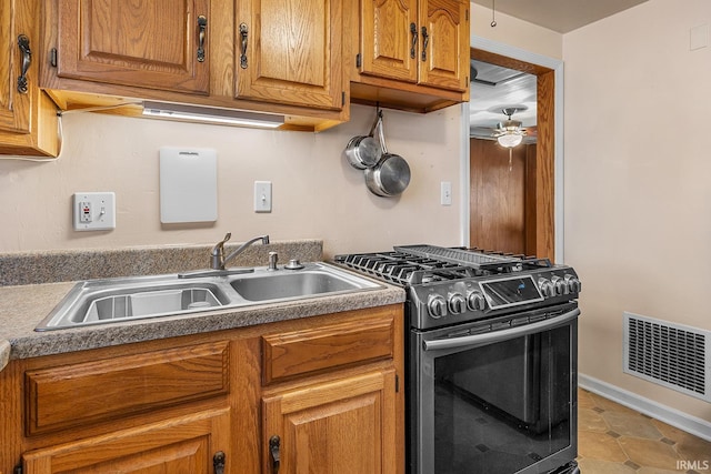 kitchen with light tile patterned flooring, sink, ceiling fan, and stainless steel gas range