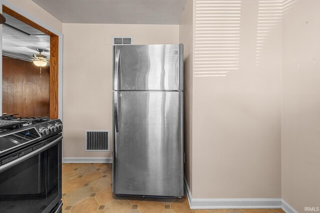 kitchen featuring stainless steel fridge, black range with gas cooktop, and ceiling fan