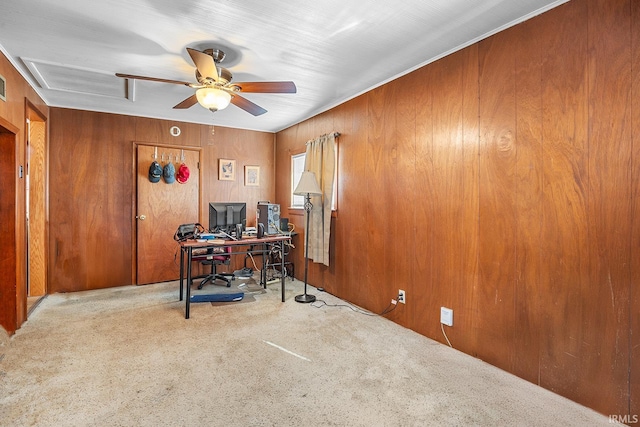 office space featuring light carpet, ceiling fan, and wood walls