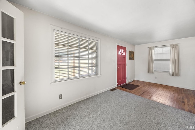 entrance foyer featuring dark colored carpet and plenty of natural light