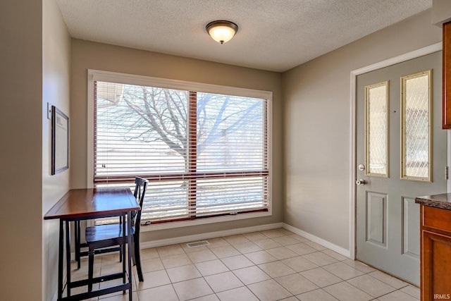 tiled dining area featuring a textured ceiling