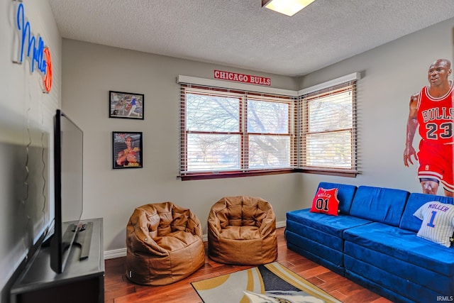 living room featuring a textured ceiling, hardwood / wood-style flooring, and a healthy amount of sunlight