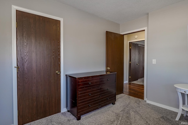 bedroom featuring a textured ceiling, light colored carpet, and a closet