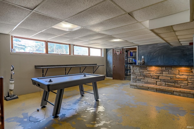 recreation room featuring a drop ceiling and concrete flooring