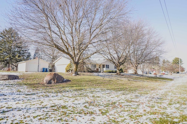 yard covered in snow with an outbuilding and a garage