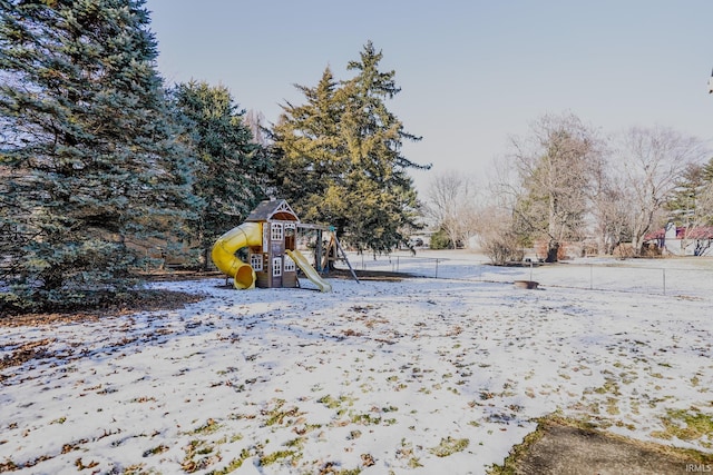 yard covered in snow with a playground