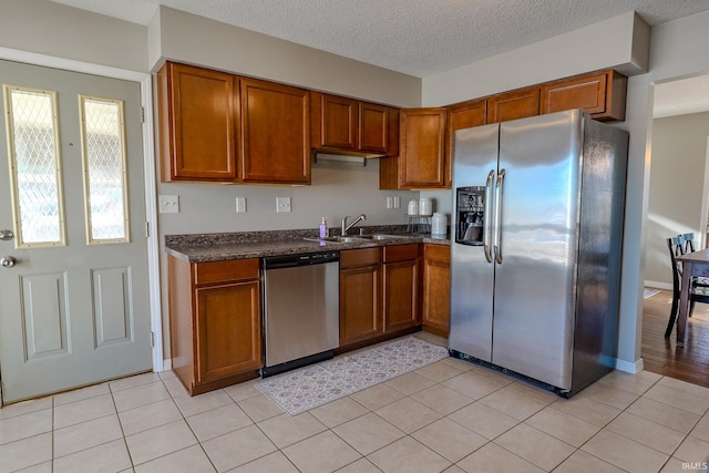 kitchen featuring sink, light tile patterned floors, and stainless steel appliances