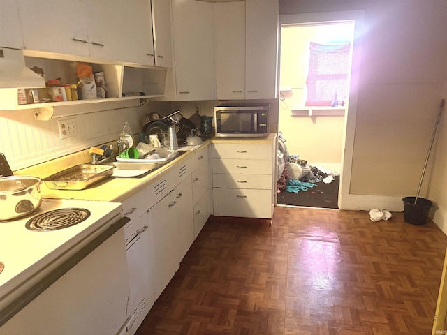 kitchen with dark parquet flooring, ventilation hood, sink, white electric range, and white cabinetry