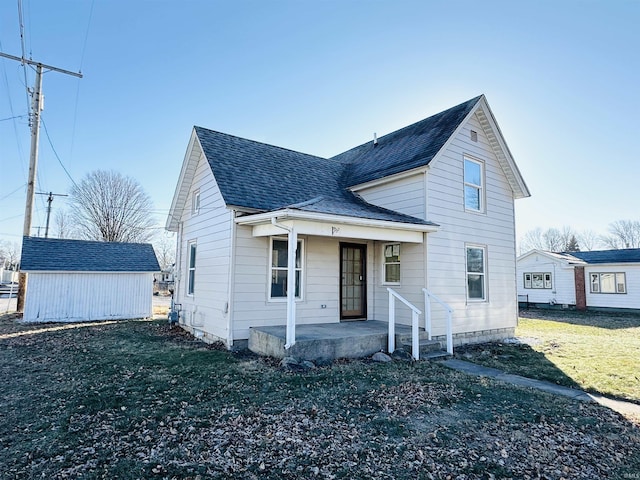 view of front of home featuring covered porch, a shed, and a front yard