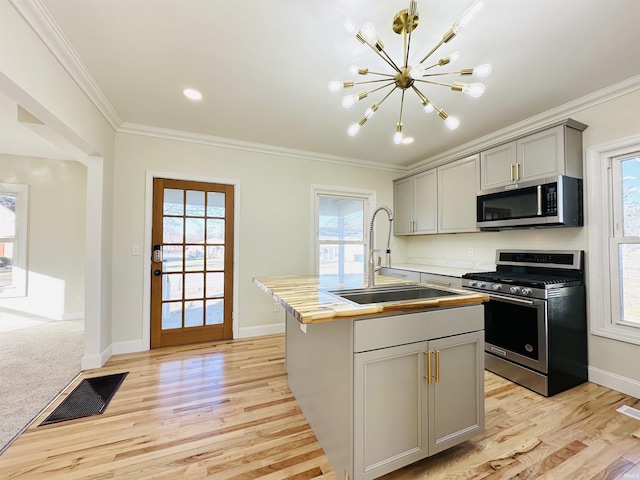 kitchen featuring gray cabinetry, crown molding, sink, and appliances with stainless steel finishes