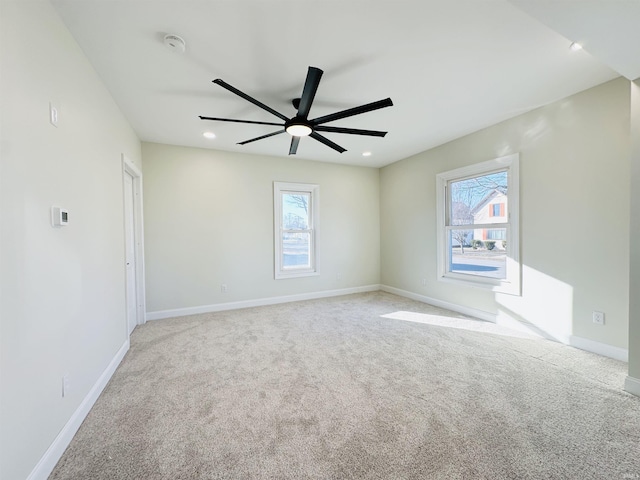 carpeted empty room with a wealth of natural light and ceiling fan