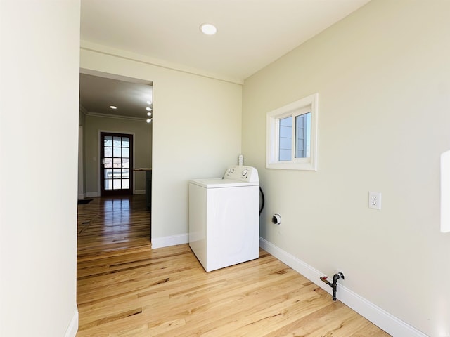 laundry room featuring ornamental molding, light wood-type flooring, and washer / dryer