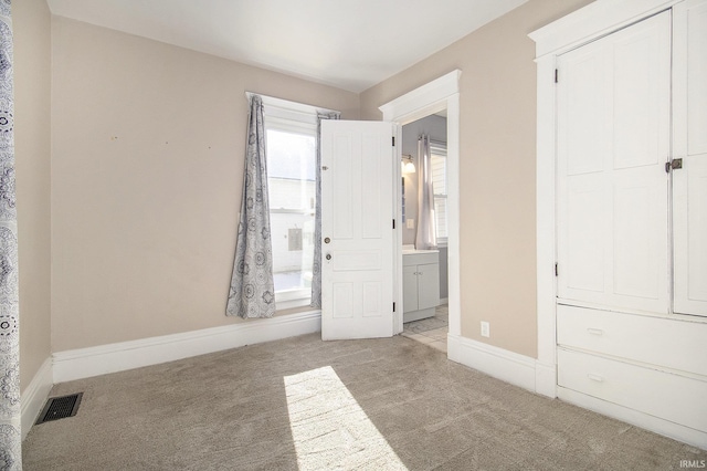 unfurnished bedroom featuring light colored carpet and a closet