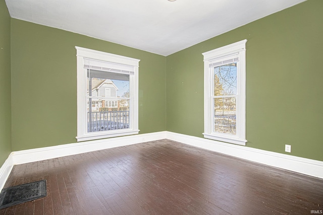 empty room featuring plenty of natural light and hardwood / wood-style flooring