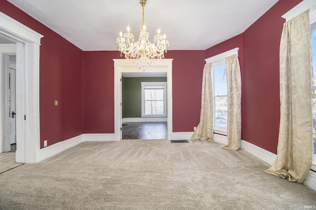 unfurnished dining area with carpet and a notable chandelier