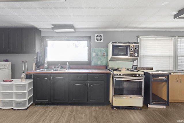 kitchen featuring white gas range, sink, and dark wood-type flooring