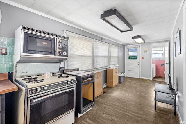 kitchen with black microwave, gas range oven, and dark hardwood / wood-style floors