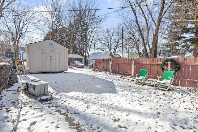 snowy yard with a storage shed