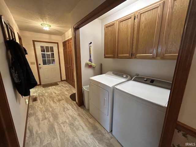 laundry room featuring cabinets, light hardwood / wood-style flooring, and washer and dryer